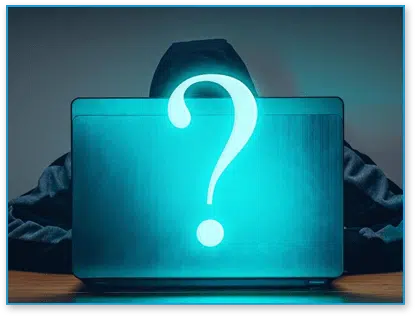 Hacker hiding behind laptop with question mark on it