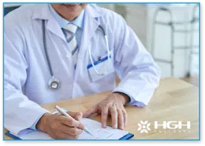 endocrinologist in white jacket holding pen and doing paperwork intake form on new HGH patient for HGH dosage