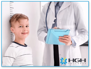 Child standing in front of size chart next to Endocrinologist